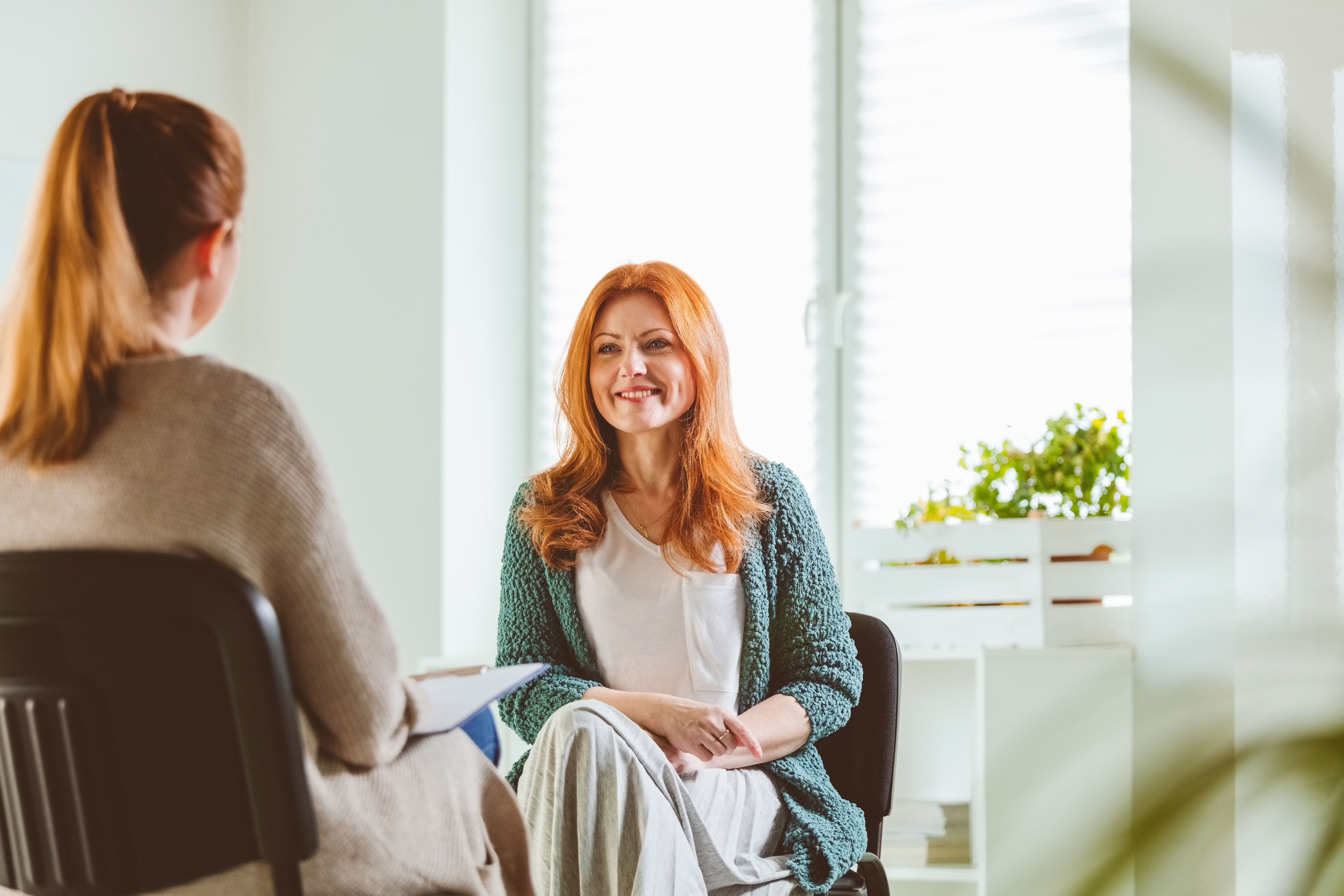 Woman in sunny office talking with a therapist