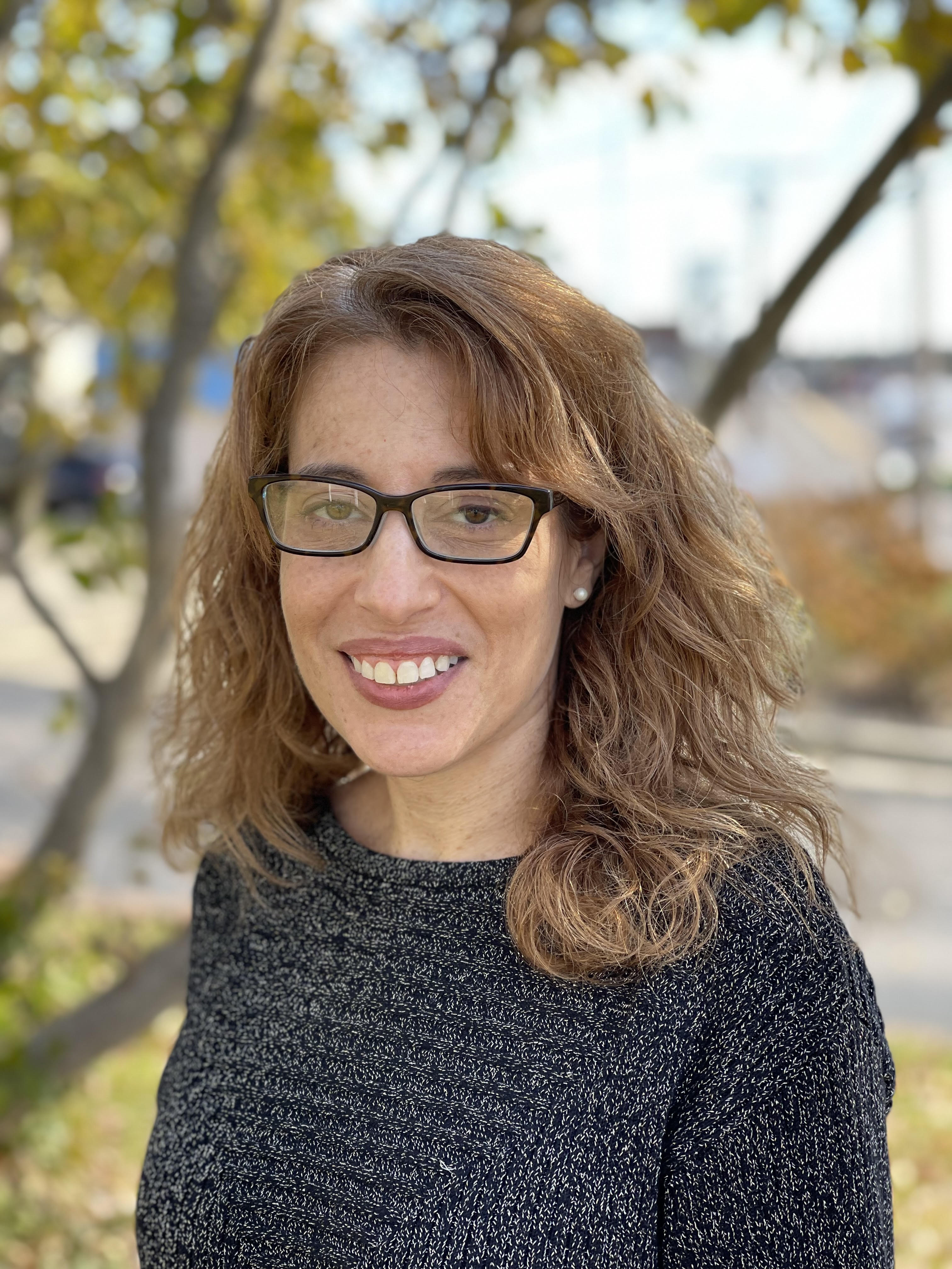 Therapist with curly hair and glasses