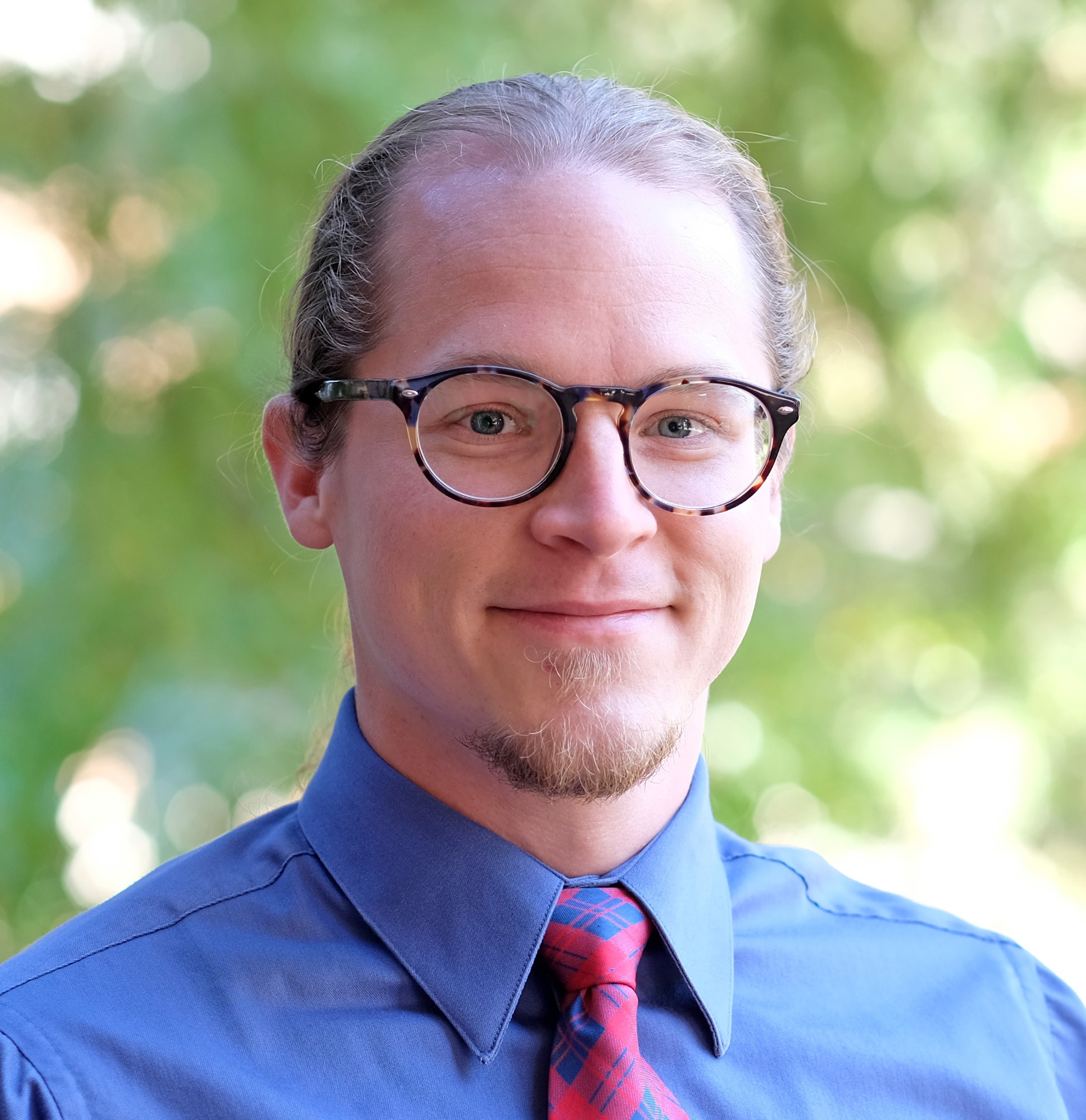 Male therapist with glasses, blue shirt