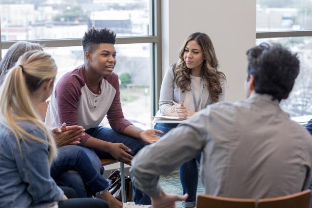 Teens meet with a professional therapist for group counseling