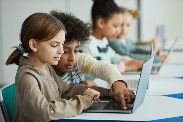 Two children use a computer. This reflects concepts of tween therapy in St Louis, MO. Our teen therapists in St. Louis, MO can help tweens and teens through CBT and play therapy in St Louis, MO.