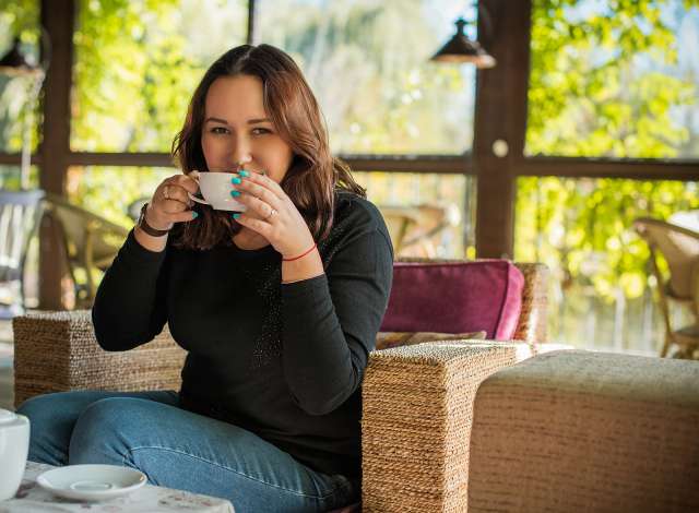 A woman drinks coffee. This relates to concepts of trauma therapy in Waldo, MO. Our trauma therapist in Waldo, MO offer effective trauma therapy in Kansas City, MO.