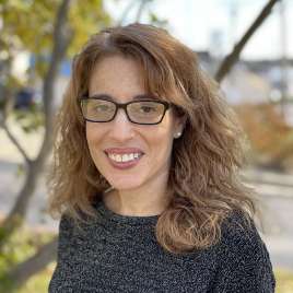 Therapist with curly hair and glasses