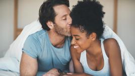 man kissing woman on the forehead