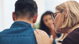 Woman consoling a man suffering with grief