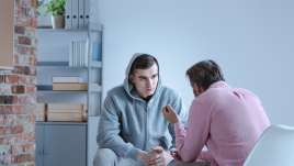 Mental health therapist meets with a troubled teenage boy
