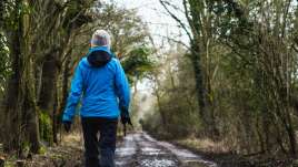 woman hiking down a forest road