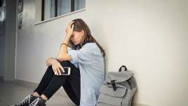 A girl leans against a wall. It appears that she could benefit from starting teen therapy in St. Louis, MO with a teen therapist in St Louis, MO. See how CBT for teens can help in teen therapy in St. Louis, MO.