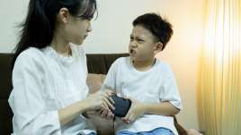 two children fighting over a toy looking argry